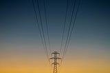 An electricity pylon against the twilit sky
