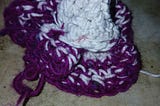 A white and magenta crocheted body of work