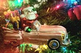 A vintage Christopher Radko Christmas ornament, Santa in a pink convertible