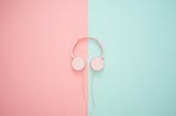 Pink headphones on a pink and green background.