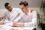 Business setting. Men sitting at a table and crying.