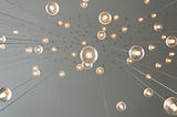 Photo of small light fixtures hanging from long wires as viewed from below.