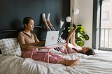 Mother and Daughter Resting on the Bed while Using Gadgets