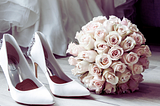 A bouquet of flowers and white wedding shoes