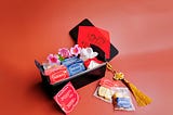 Tiny tea and biscuits hamper box on red background