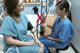 A nurse checking a woman’s BP (incorrectly) in a hospital setting
