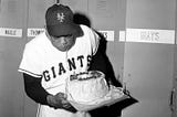 Willie Mays blowing out candles on his birthday cake