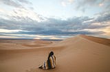 Woman sitting on the sand alone