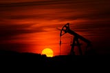 IMAGE: An oil well pumping in a dramatic red sunset