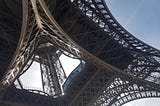 The eiffel tower seen from underneath, showing the metal structure.