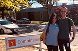 My cofounder and me standing outside next to the Y Combinator building sign.