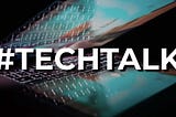 Decorative Image — bold white text: #TECHTALK over a stylised photo of a partially opened bright laptop screen