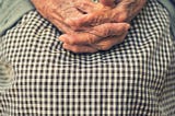 This picture shows the crossed fingers of an older person.