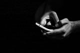 A grayscale photo of someone holding a cell phone