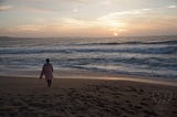 Miranda on the beach, looking towards a waning sunset in California