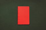 Photo of a red notebook on a green surface