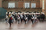 A marching band leaving a building