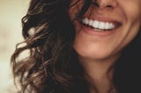 Woman smiling widely with top half of her face cropped