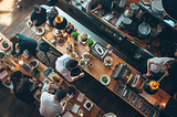 Overhead view of a bustling restaurant kitchen with chefs preparing various dishes.