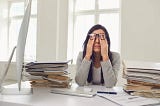 A photo of someone dealing with the stress, pain, and dysfunction inherent in many of today’s modern workplaces.