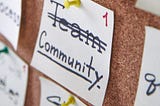 note cards pinned to cork board with “community” written on it