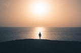 Man facing sunrise over ocean.