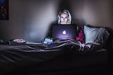 woman using a laptop in bed