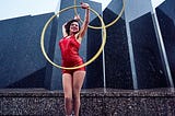 The Hula Hoop Method For Writers. Woman in red dress doing hula hoop.