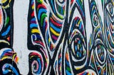 Graffiti showing an abstract image of bands of colour mixing and crossing paths