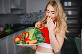 How to Lose Weight at Home Without Exercising (image of a woman holding vegetables in a plate)