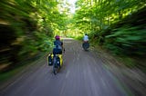 Two people riding bicycles.