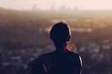 A woman looks out on cityscape