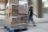 Workers moving boxes in warehouse.