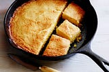 Color photo of cornbread in a cast-iron pan