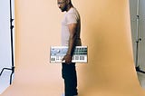 Chris Craft aka CRFT holding a microKorg synthesizer keyboard