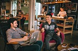 Men having a conversation while sitting in chairs.