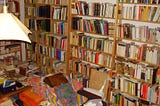 Image of Clutter: A room filled with books packing all bookcases, tables and all along the floor with no room to move or access the bookcase safely