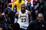 LeBron James heads down a tunnel surrounded by security and police officers after the conclusion of a Lakers game.