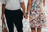 An older couple holding hands.