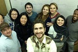 Photo of smiling students and teacher in a classroom.