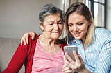 Young woman and her grandma looking at a cell phone