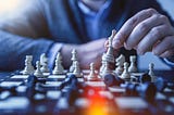 Photo by JESHOOTS.COM on Unsplash. A man playing chess, wearing an office business suite and likely winning the game against the opponent. Indicating the power of informed decisions similar to how having the information can help to make informed decisions in the areas of investment and finance.
