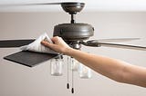 How can you clean a ceiling fan without taking it down from the roof or using an electric broom?