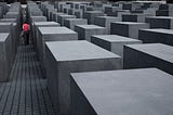 In the distance, a person is walking through the 2,711 concrete slabs, arranged in a grid pattern.