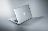 A gray MacBook on a gray background.