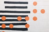 Photo of a pattern of horizontal black lines disrupted by orange dots