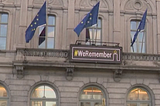 A building with a We Remember sign and the Jewish flags.