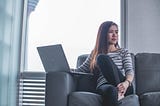 Woman sitting on couch pondering