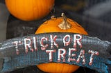 Pumpkin with sign reading “Trick or Treat.”