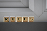 A group of Scrabble tiles that spell out “RULES”.